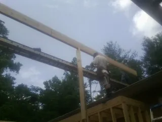 Carpenter setting a ridge beam over a new addition frame — Ice Dam Removal by Roofing Brothers in San Dimas